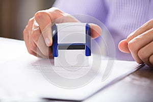 Close-up Of A Person Stamping On Document