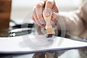 Close-up Of A Person Stamping On Document