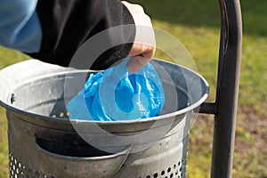 Close-up of  person throwing  shoe-covers away