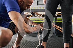 Close up personal trainer measuring calve with tape