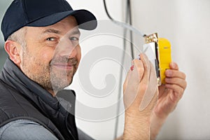 close-up persons hand installing socket on wall at home