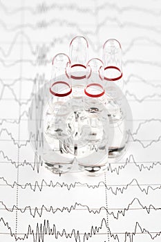 Close-up photo of ampoules with medicine on EKG graph