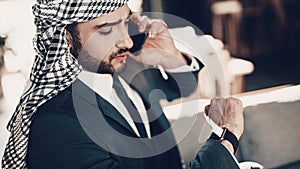 Close up photo of Arab looking at wristwatches