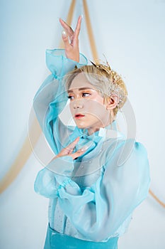 close up photo of an Asian woman with short blonde hair and wearing a blue dress