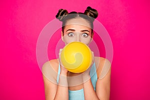 Close up photo of astonished youth holding baloon inflating wearing blue singlet isolated over fuchsia background