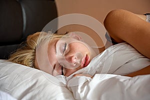 Close up photo of an attractive young woman sleeping in bed