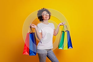 Close up photo beautiful girl carry shopping bags posing on yellow background
