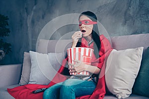 Close up photo beautiful she her superpower lady costume hold popcorn container controller change channels scary movie