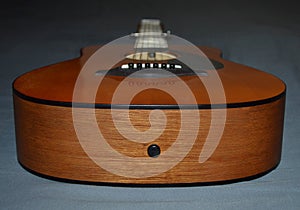 A close-up photo of a brown and black child`s acoustic guitar head