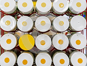 Close up photo of bunch of spray multicolored paint cans on shelf b