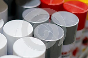 Close up photo of bunch of spray multicolored paint cans on shelf b