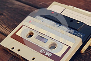 Close up photo of cassette tape over wooden table . top view. retro filtered