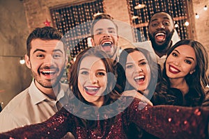 Close up photo of cheerful multiethnic group of fellows laugh scream have fun at christmas night x-mas party make selfie