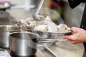 Close up, photo of chef hands adding a sauce to a tray with food.