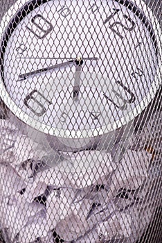 Close-up photo of a clock in refuse bin with other