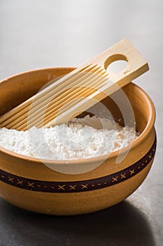 close up photo of cooking ingredients like a bowl of flour and mold of pasta