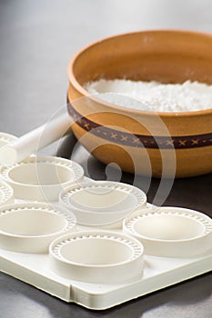 close up photo of cooking ingredients like a bowl of flour and mold of pasta