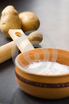 close up photo of cooking ingredients like a bowl of flour, some potatoes and mold of pasta