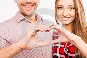 Close up photo of couple in love making heart with fingers