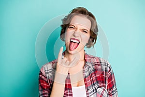 Close up photo of crazy funky teen girl enjoy pank music concert show tongue out make horned symbol scream feel rejoice