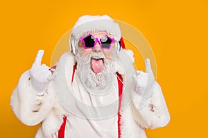 Close up photo of crazy funny hipster santa claus show horns sign tongue-out want rock-and-roll concert instead x-mas