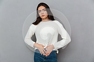 Close-up photo of depressed young woman with abdominal pain, loo