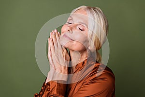 Close up photo of dreamy good mood woman dressed silk shirt with blond hairstyle holding palms together  on