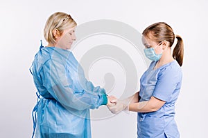 Close-up photo of a female caregiver and senior woman patient holding hands. Senior care concept. Young female doctor