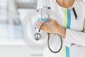 Close-up photo of female doctor holding stethoscope