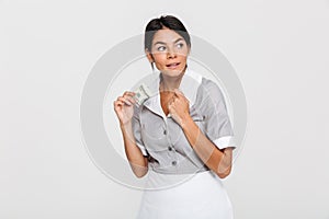 Close-up photo of female housekeeper in uniform hiding her tips