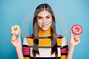 Close up photo of flirty attractive girl hold two doughnuts want eat feel dream desire bite teeth lips wear good look