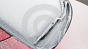 Close up photo of frozen windshield and car wiper in winter
