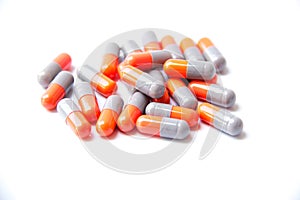 Close-up photo of Gray orange pills isolated on white background