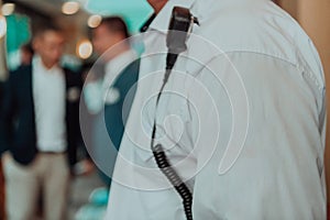 A close-up photo of a guard holding a communication device