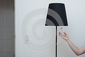 Close-up photo of A hand changes a light bulb in a stylish loft lamp from the bottom side