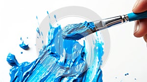 Close-up photo of a hand holding a paintbrush dipped in bright blue paint