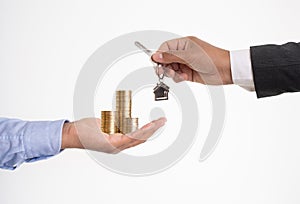 Close up photo of hands exchanging money and house key on isolated background