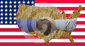 Close up photo of a handshake between afroamerican and european hands. Handshake in front of US flag. On the flag are the contours