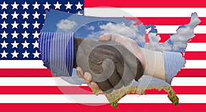 Close up photo of a handshake between afroamerican and european hands. Handshake in front of US flag. On the flag are the contours