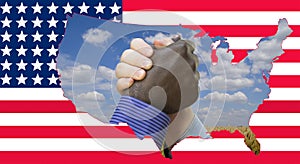 Close up photo of a handshake between afroamerican and european hands. Handshake in front of US flag. On the flag are the contours