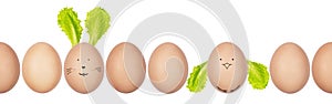 Close-up photo of henâ€™s eggs with eggshell texture in a row. Funny Easter bunny and chicken made of eggs and salad leaves.