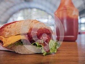 Close-up photo of home made hamburger with beef, onion, tomato, lettuce, cheese and spices. Fresh burger closeup on wooden rustic