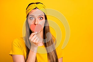 Close up photo of impressed youth hide her face with paper card heart dint share news isolated over yellow background