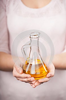 Close up photo of jug with oil in female hands