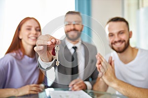 Close-up photo of keys, realtor giving key from apartment to owners