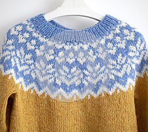 a large blue, white, yellow yoke of a knitted wool lopapeysa sweater in traditional Icelandic knitting pattern