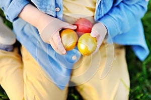 Close-up photo of little boy hunting for easter egg in spring park on Easter day