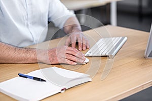 Close-up photo of man`s hands in the office working with a computer keyboard
