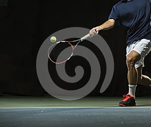 Close up photo of a man swinging a tennis racquet during a tennis match photo