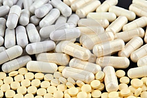 Close-up photo of many white and yellow pills